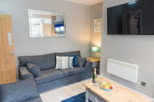 een woonkamer met een bank en een tv bij Charming 6 Bedroom House ALL with en-suite - Large Garden in Tamworth