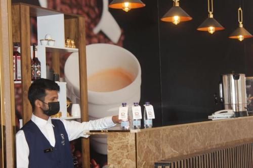 a man wearing a face mask at a bar at فندق روند in Hafr Al Baten