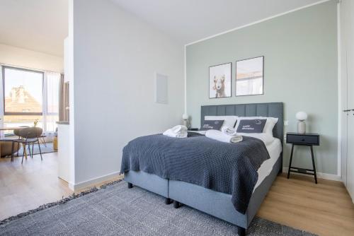 a bedroom with a bed with a blue blanket at Limehome Aalen Reichsstädter Str in Aalen