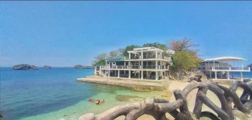 a large house on a beach next to the water at Carribean Transient House in Lucap