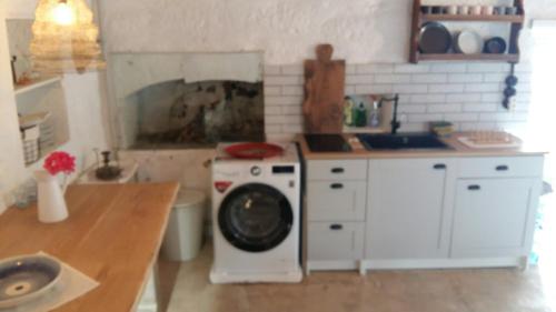 cocina con lavadora y fregadero en White Sea Houses Village, en Kimolos