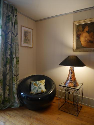 a living room with a black ottoman and a lamp at Gîte Madeleine et Clémentine in Gueberschwihr