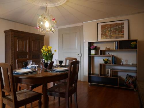 a dining room table with chairs and a chandelier at Gîte Madeleine et Clémentine in Gueberschwihr