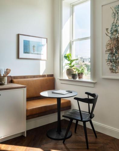 a room with a bench and a table and a chair at The Pinch Charleston in Charleston