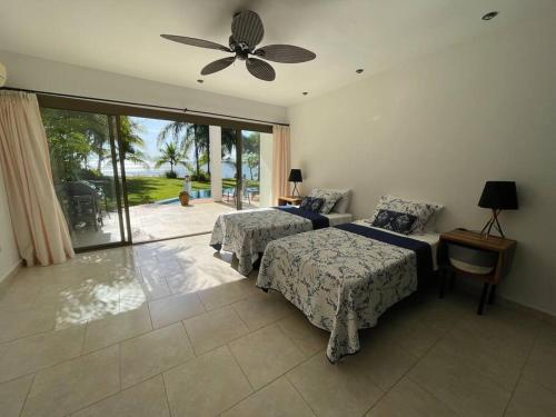 San Lorenzo的住宿－Stunning Oceanfront 4-Bdrm Villa w/ Infinity Pool，一间卧室配有两张床和吊扇