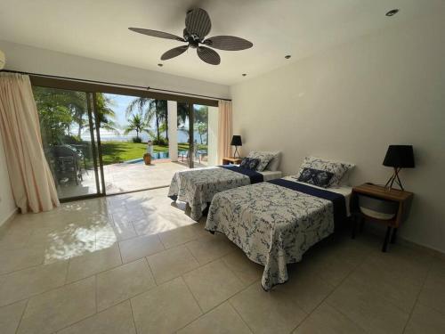 a bedroom with two beds and a ceiling fan at Stunning Oceanfront 4-Bdrm Villa w/ Infinity Pool in San Lorenzo
