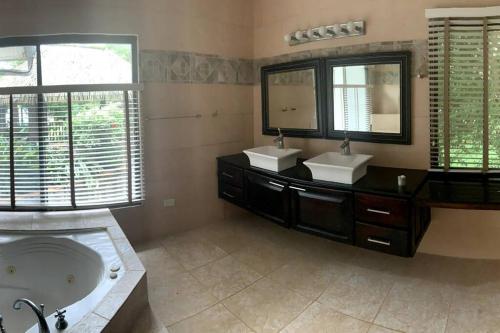 a bathroom with two sinks and a bath tub at Stunning Oceanfront 4-Bdrm Villa w/ Infinity Pool in San Lorenzo