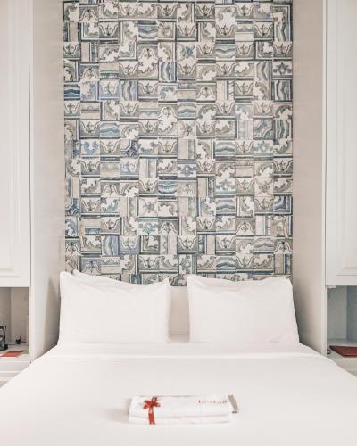 a bed with two pillows in front of a wall at Dare Lisbon House in Lisbon