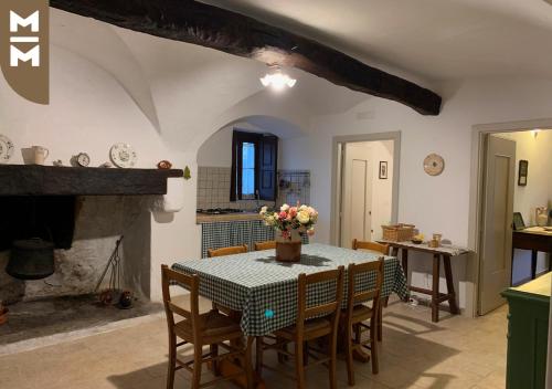 a kitchen and dining room with a table and a fireplace at Masseria Mangiato 1557 in Alberobello