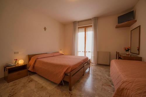 a bedroom with two beds and a window at Hotel Santa Maria in Assisi