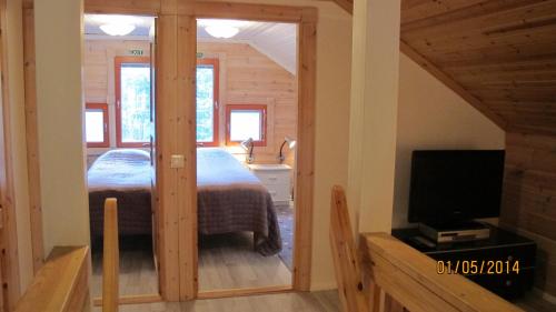 a bedroom with a bed and a tv in a room at Lomakulkuri Apartments in Vuokatti