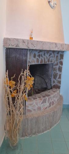 a stone fireplace with a vase in a room at Casa Vacanze Elianto in Anzio