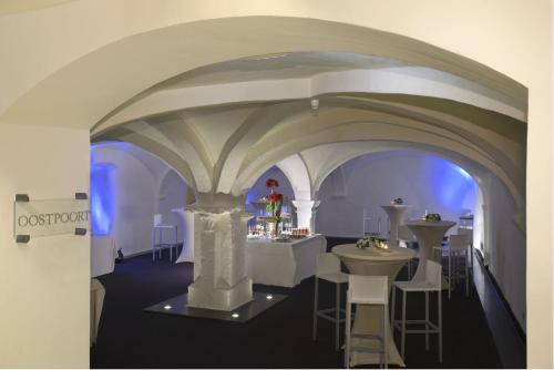 a room with tables and chairs and a white ceiling at Crowne Plaza Hotel Brugge by IHG in Bruges
