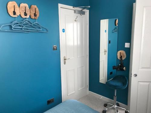 a blue room with a chair and a mirror at Amarillo Guesthouse in Bournemouth