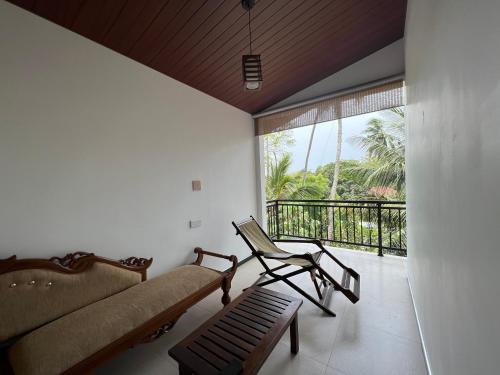 a living room with a couch and a chair and a balcony at Tanzanite place in Tangalle