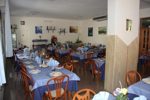 jadalnia z niebieskimi stołami i krzesłami w obiekcie Hotel Vela Azzurra w Rimini