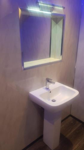 a bathroom with a white sink and a mirror at Highfields Living - All Rooms Ensuite- Free Wifi- Free Local Parking in Sheffield