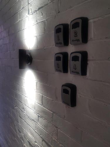 a wall with four toasters on a brick wall at Highfields Living - All Rooms Ensuite- Free Wifi- Free Local Parking in Sheffield
