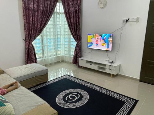 a living room with a tv and a couch at Arwaa Homestay Beachview in Bachok