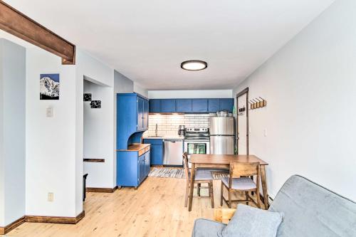 a kitchen with blue cabinets and a wooden table at Prismatic Mountain Studio Less Than 1 Mi to Big Sky Resort in Big Sky