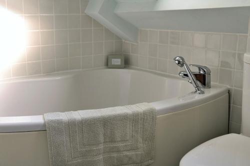 a bathroom with a tub and a toilet and a towel at Finest Retreats - Dolwar Cottage in Ffestiniog