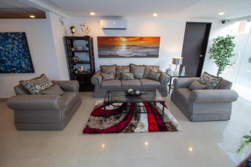 a living room with two couches and a coffee table at Hotel Villas Segovia Playa del Carmen in Playa del Carmen