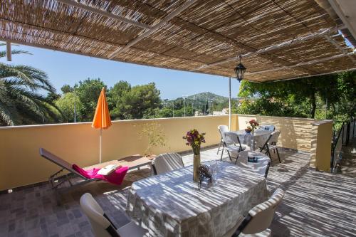 eine Terrasse mit einem Tisch, Stühlen und einem Sonnenschirm in der Unterkunft Apartments Djurkovic in Mlini