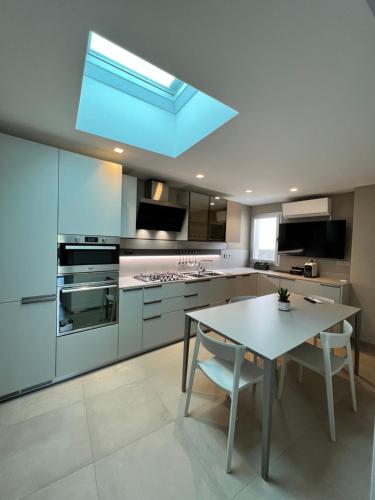eine große Küche mit einem Tisch und einem Dachfenster in der Unterkunft MP Luxury House in Budoni
