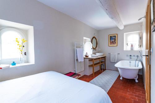 une chambre avec un lit, une baignoire et un lavabo dans l'établissement Belle De Jour -A Provencal gem Private heated pool, à Gordes