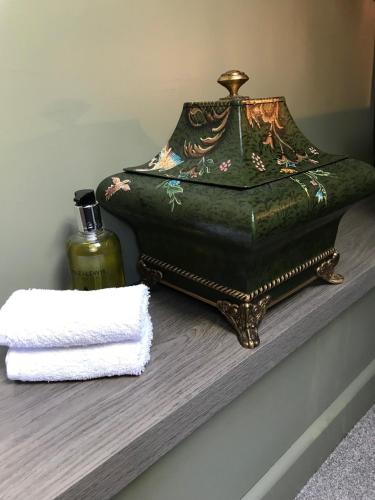 a table with a bottle of perfume and a towel at Amarillo Guesthouse in Bournemouth