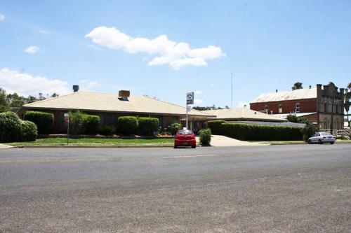 a red car is parked in front of a house at Mid Town Inn Narrabri in Narrabri