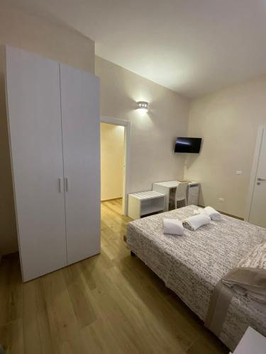 a white bedroom with a bed and a white cabinet at La maison del porto in San Foca