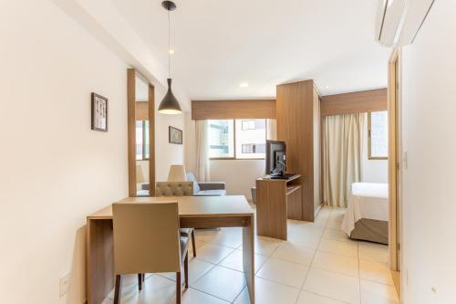 a room with a dining table and a bedroom at Beach Class Santa Maria by Easy Home in Recife