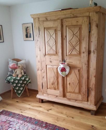 a large wooden cabinet in a room with a chair at Sunrise Retreat in Bad Blumau