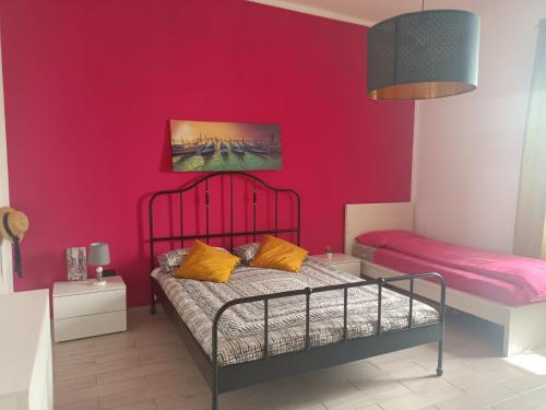 una camera con letto e parete rosa di Agata2020 a Mondragone