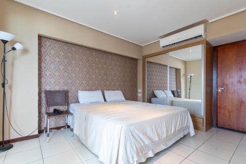 een slaapkamer met een groot wit bed en een spiegel bij Interatlântico #809 - Apê em Natal por Carpediem in Natal