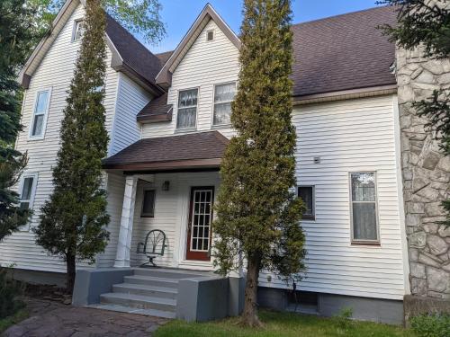 a white house with a brown roof at Hill Road Manor Bed & Breakfast in Grand Falls -Windsor