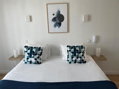 a bedroom with a bed with black and white pillows at Hôtel Porte Mars Reims Gare Centre Arena in Reims