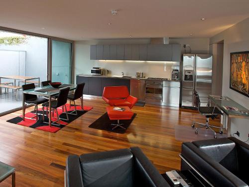a living room with a table and a kitchen at Sullivans Cove Apartments in Hobart