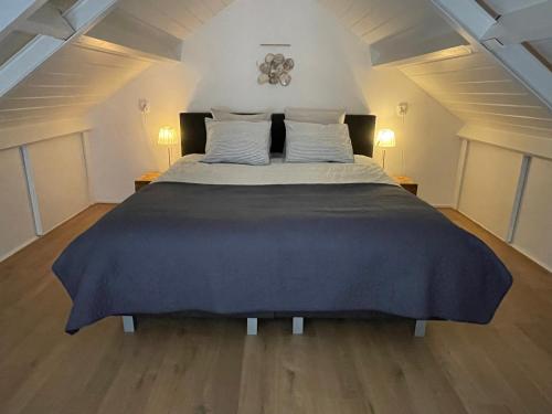 a bedroom with a large bed in a attic at Slapen op het platteland in Bodegraven