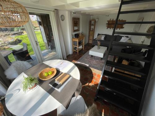 een woonkamer met een tafel en een wenteltrap bij Slapen op het platteland in Bodegraven