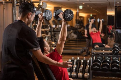 a group of men lifting weights in a gym at Four Seasons Hotel Kyoto in Kyoto