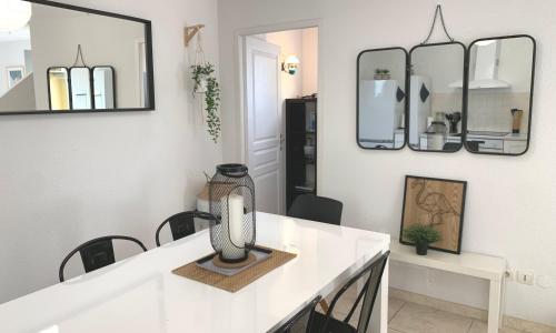 Cette chambre dispose d'une table avec un vase. dans l'établissement Maison T4 -Jardin+ Parking+ Clim -Proche Remparts, à Aigues-Mortes