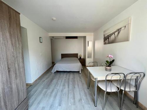 a bedroom with a bed and a table and chairs at Hotel l'Etape in Villeneuve-Loubet