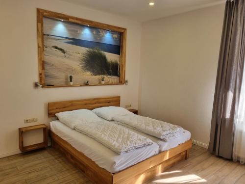 a bedroom with a bed with a picture on the wall at Ferienwohnung im Ostseebad Göhren in Strandnähe, Kurhaus Nordstrand,Nähe Binz und Sellin in Göhren