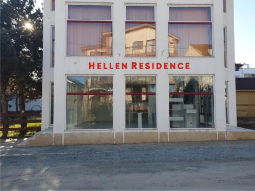 a white building with a hellen residence sign on it at Hellen Residence in Costinesti