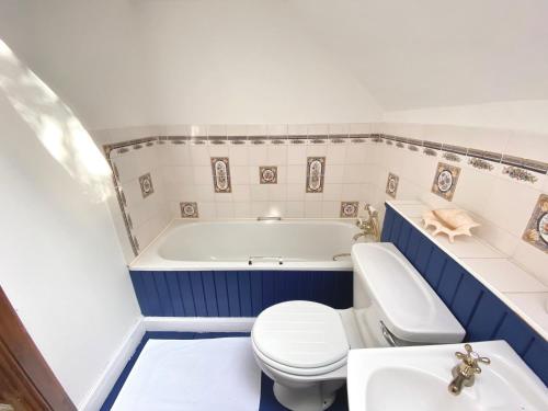 ein Badezimmer mit einer Badewanne, einem WC und einem Waschbecken in der Unterkunft The Bothy of Ballachulish House in Ballachulish