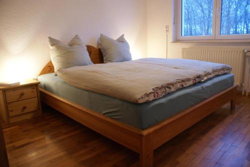 a bedroom with a bed with pillows and a window at Ferienwohnung Zum Kirschhof in Hofbieber