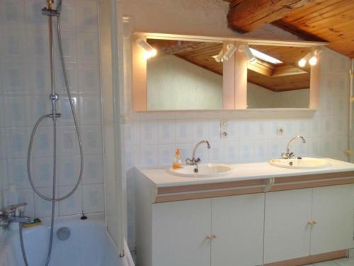 a bathroom with two sinks and a shower and a mirror at Gîte Renaison, 4 pièces, 6 personnes - FR-1-496-257 in Renaison