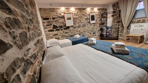Cama en habitación con pared de piedra en Soggiorno Madrid, en Florencia